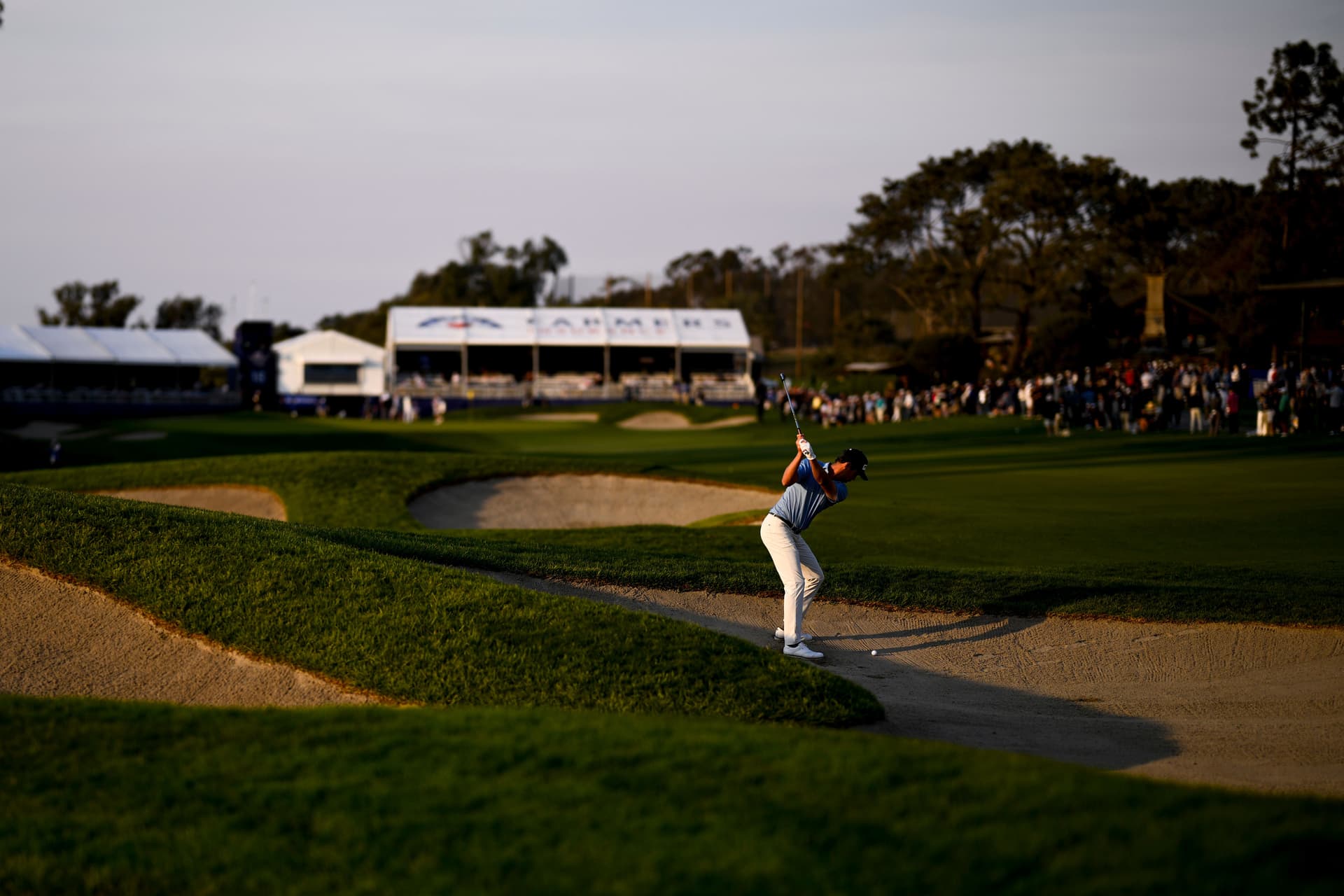 Harris English hits out of a fairway bunker on the 18th hole during the third round